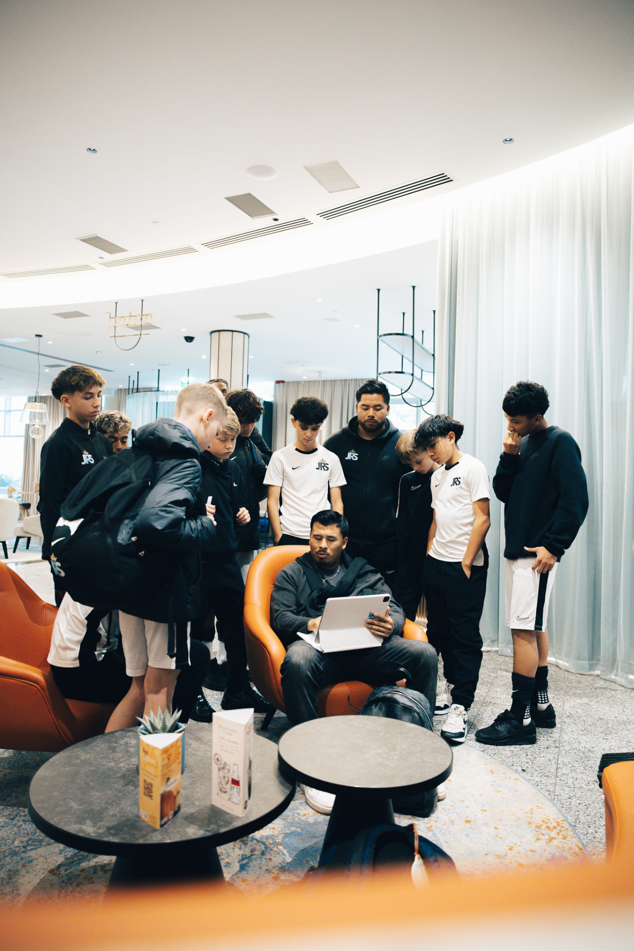 JRS players gather around their coach as he reviews the game plan on a tablet before a match in Wrocław, Poland.