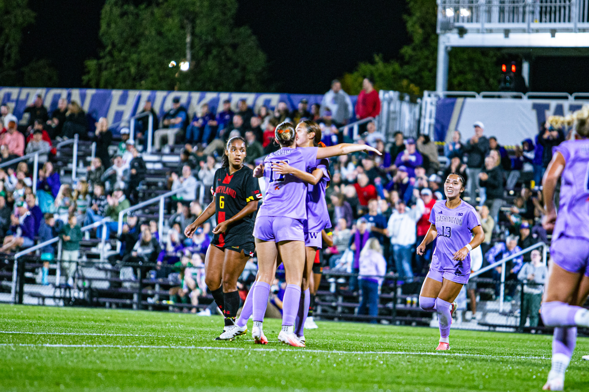 Washington women's soccer players celebrate during a match against Maryland.