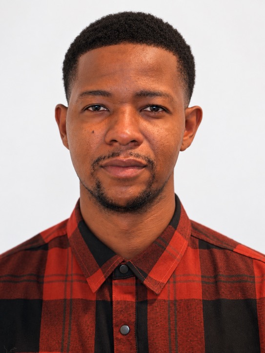 Ryan, Suubi Media editor, in a red and black plaid shirt.