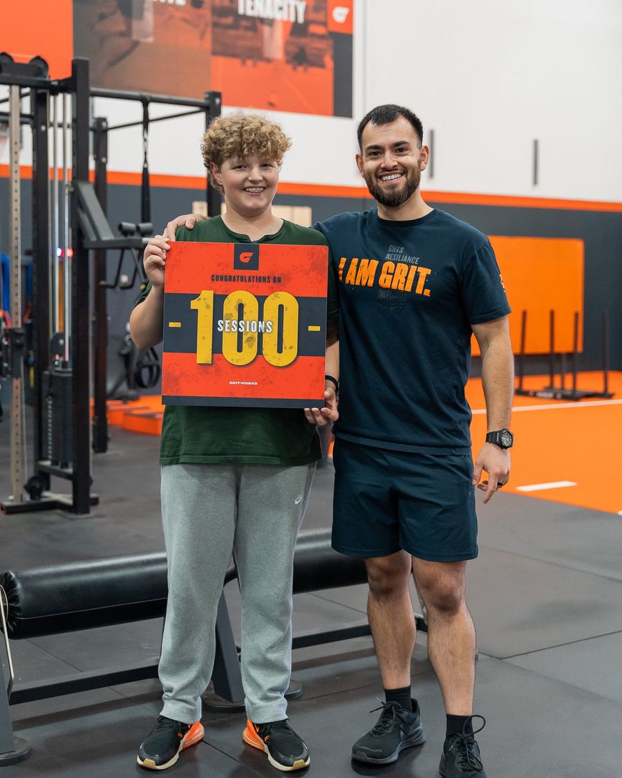May 2026: athlete and coach holding a 100 sessions sign