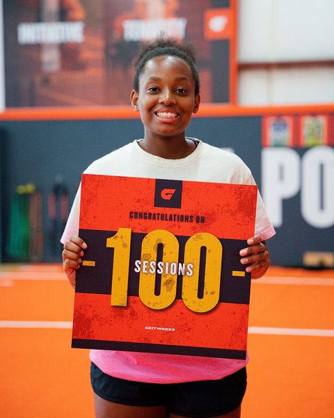 Athlete holding her 100 sessions sign