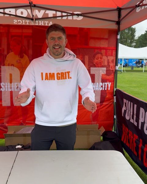 Coach in an I AM GRIT hoodie at the Gritworks tent