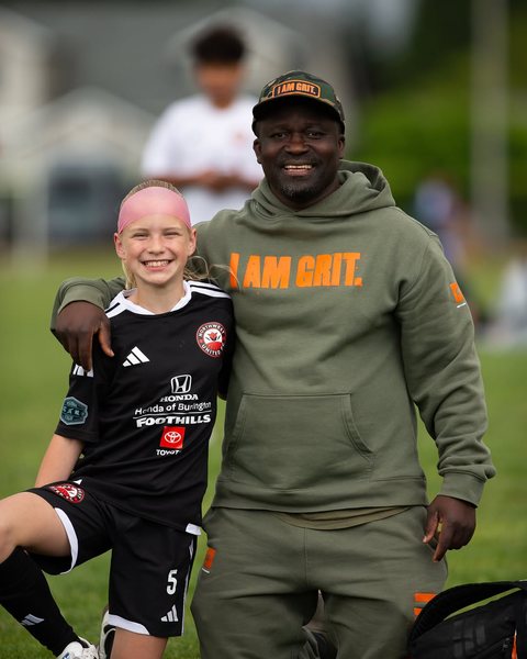 Coach with a young soccer player at a tournament