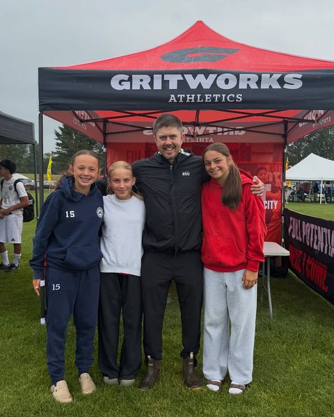 Athletes with a coach at the Gritworks tournament tent