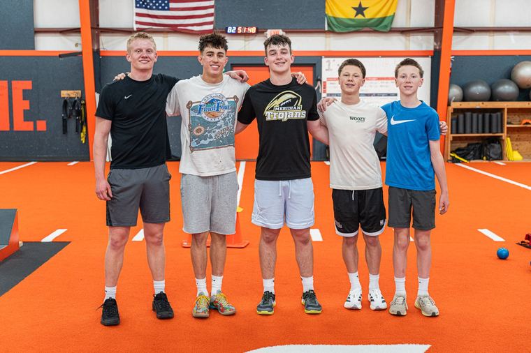 Five athletes lined up on the turf