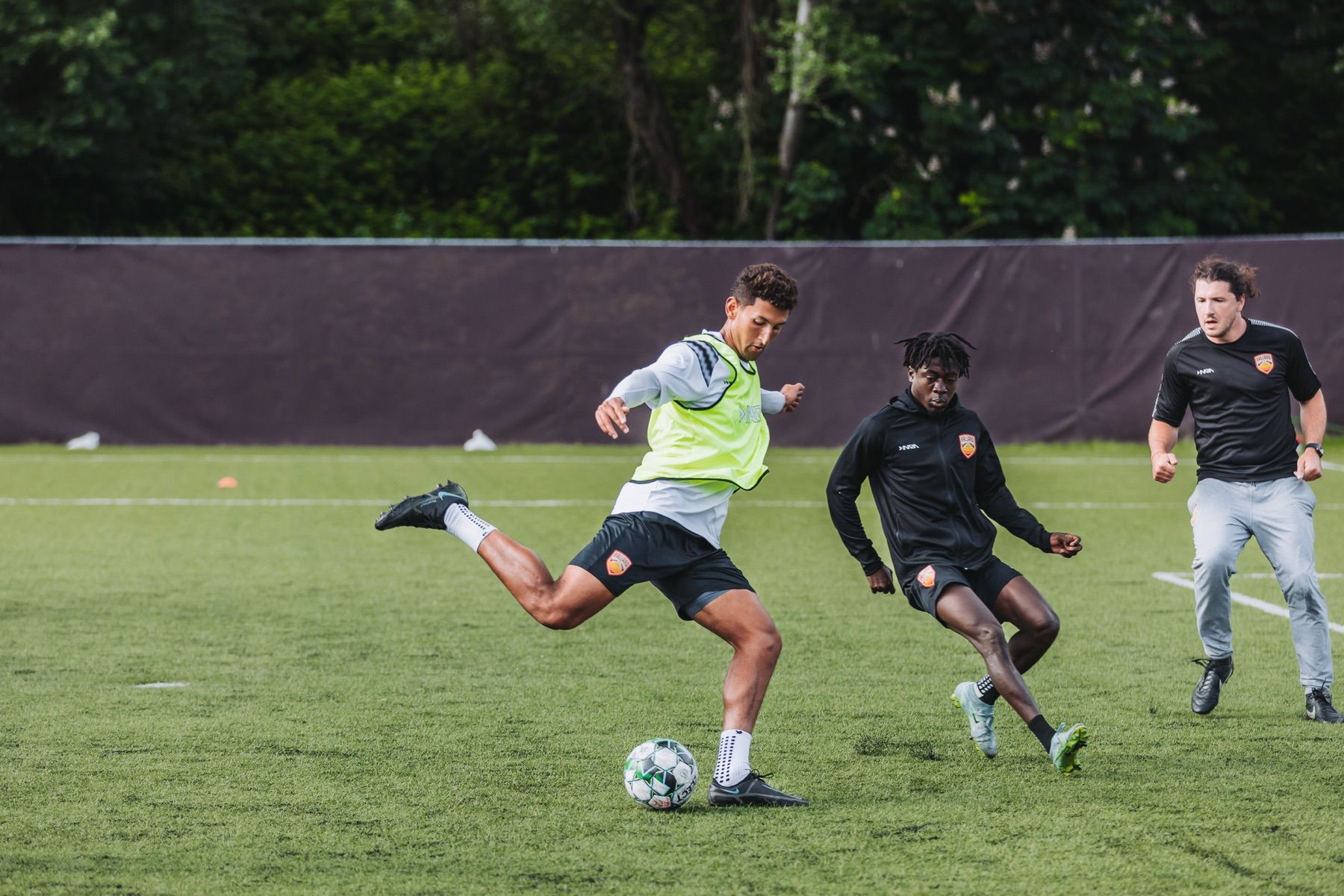 Soccer players compete for the ball during an outdoor training session.