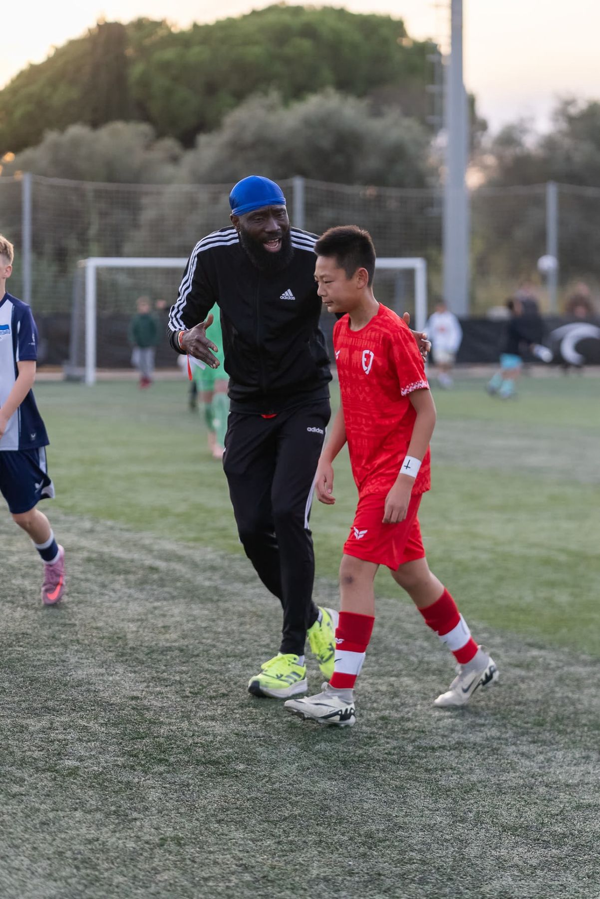 A coach works one on one with a player during an EJ Futball training session in Spain.