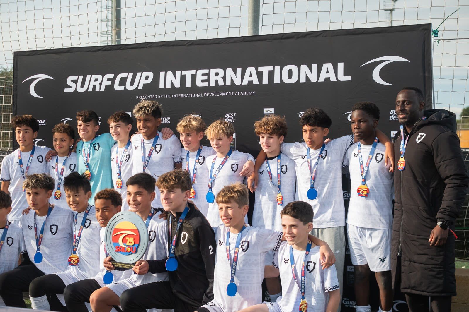 A team poses with medals on the Surf Cup International podium in Spain.