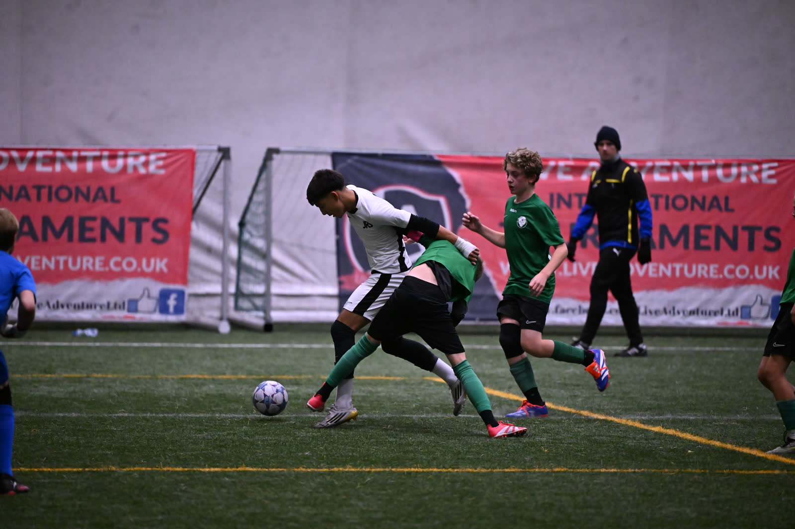 A JRS player holds off two challenges in a crowded tackle at the Number One Cup in Wrocław, Poland.