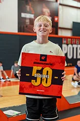 A young athlete holds up a sign with the number 50