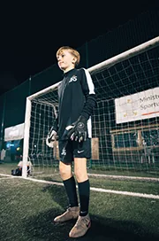 A goalkeeper stands in front of the net