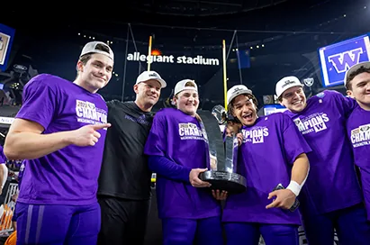 Players in purple champions shirts hold up a trophy at Allegiant Stadium
