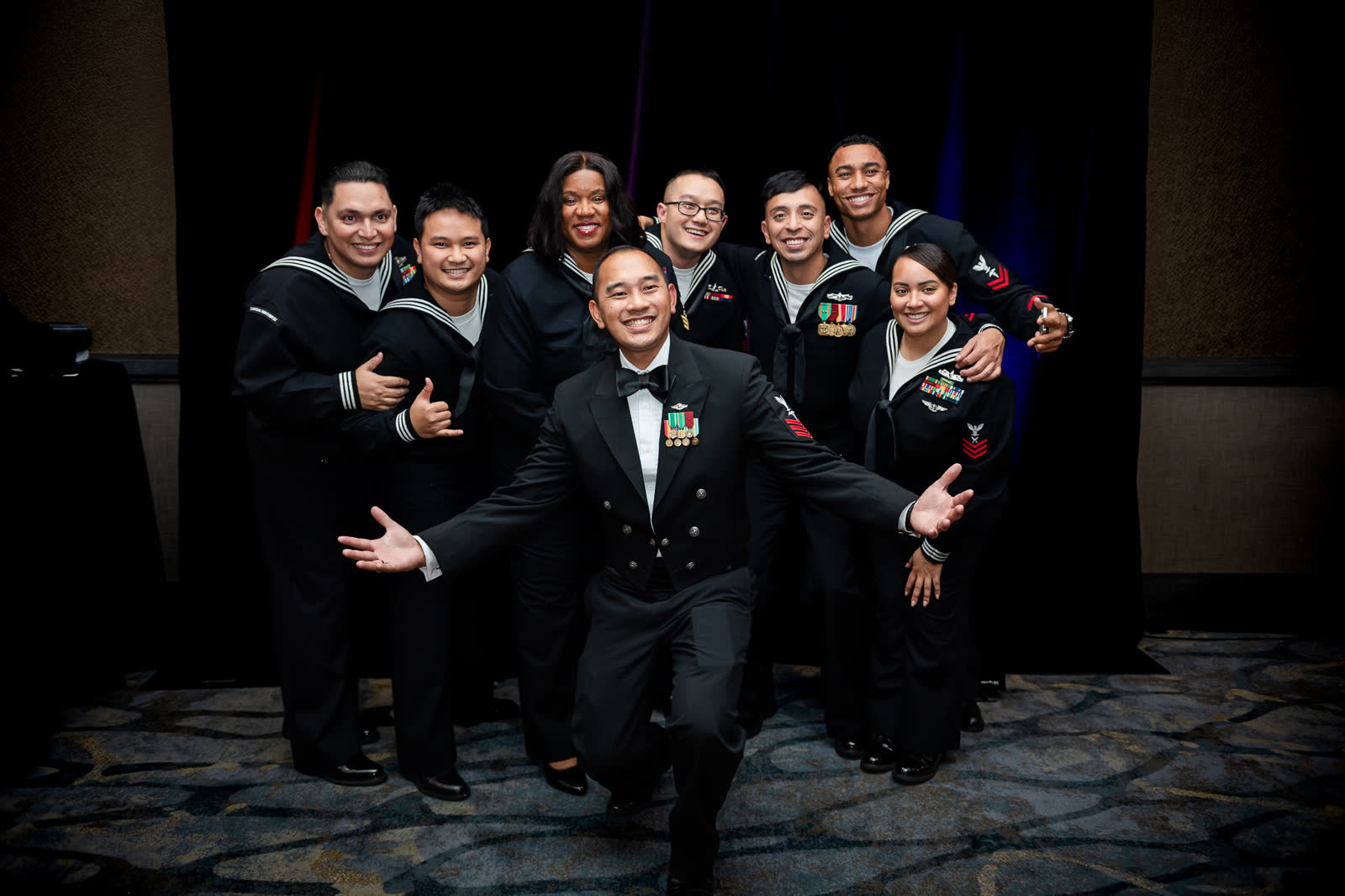 A group of sailors laugh through a playful posed portrait at the Navy Ball in Everett.