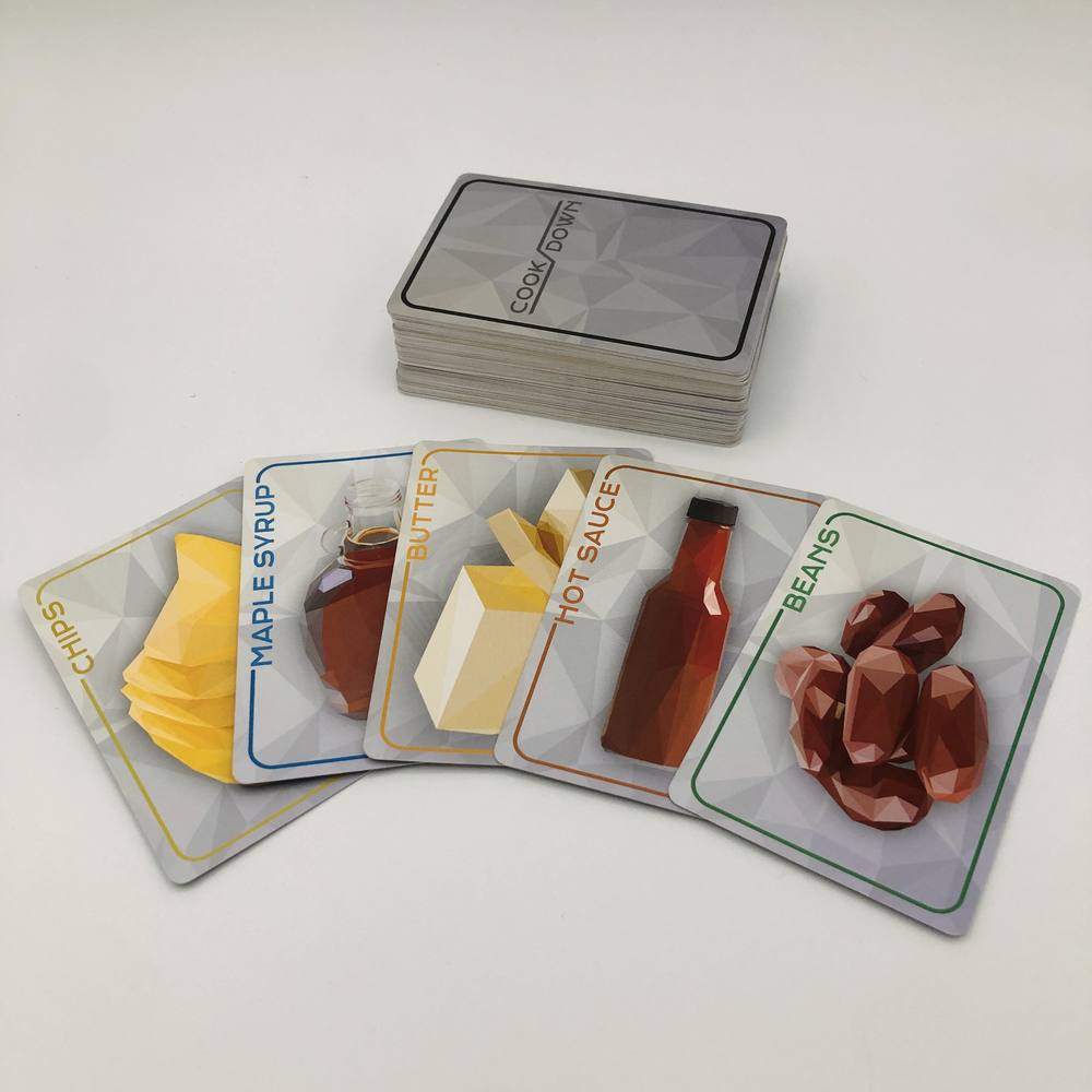 A hand of Cookdown ingredient cards: chips, maple syrup, butter, hot sauce and beans